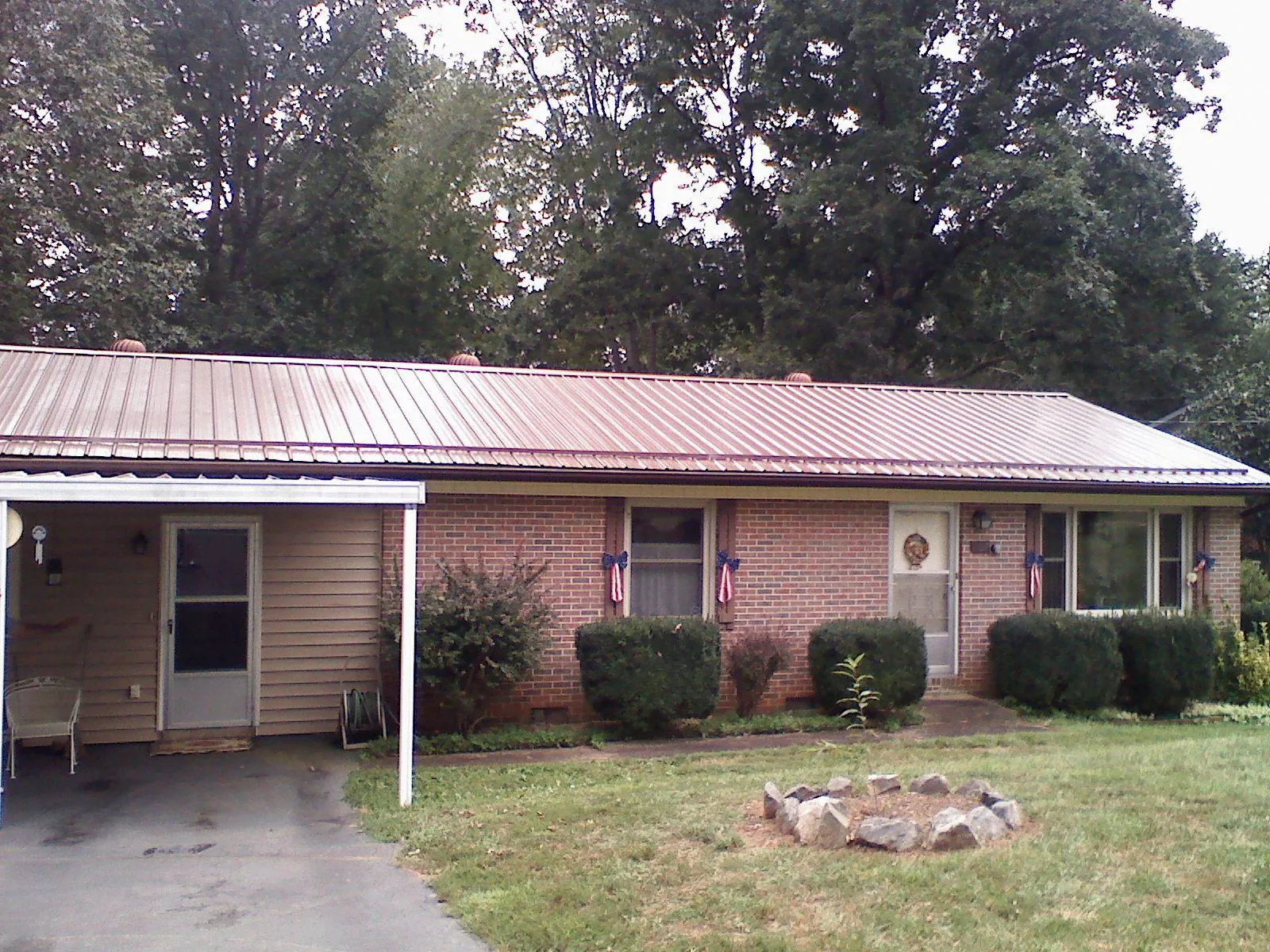 Bronze metal roof and carport on a brick ranch home — Roof Repair work by our crew in Big Bend